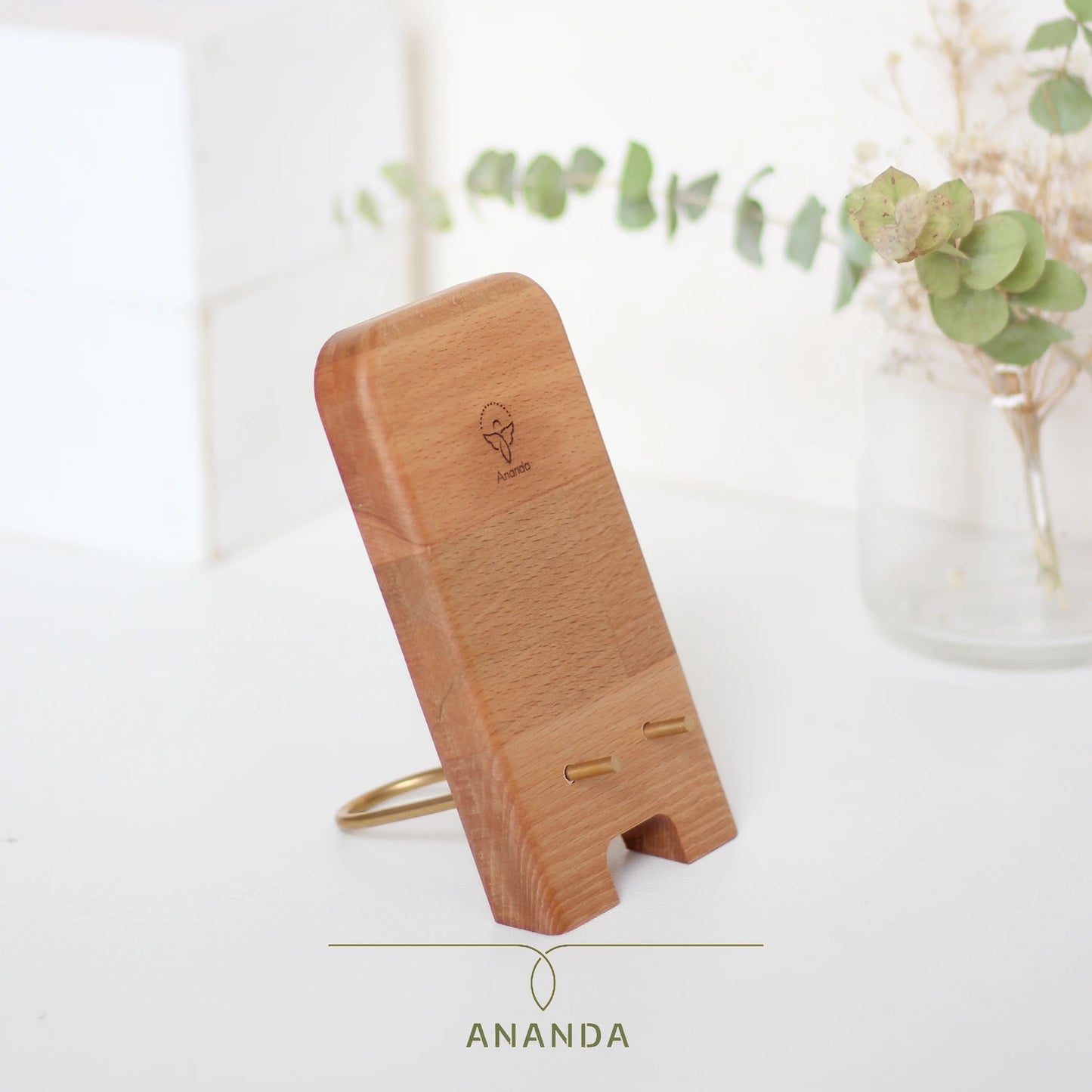 Beech wood and brass phone holder in use with smartphone, shown on a modern desk – perfect for charging and display.