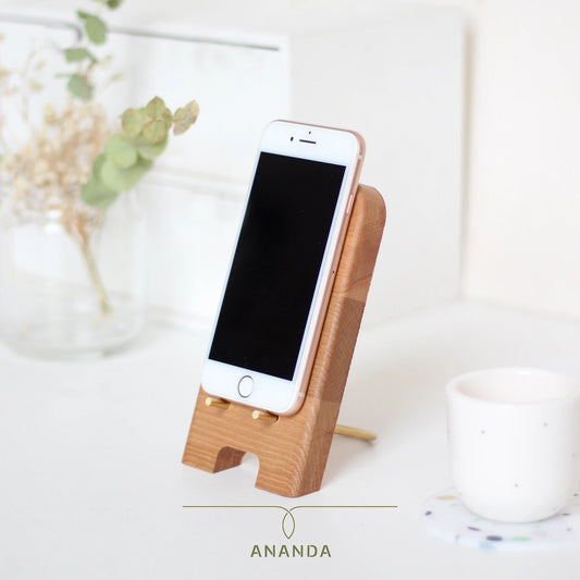 Front view of a beech wood mobile phone holder with solid brass base and visible cable slot – minimalist and elegant design.
